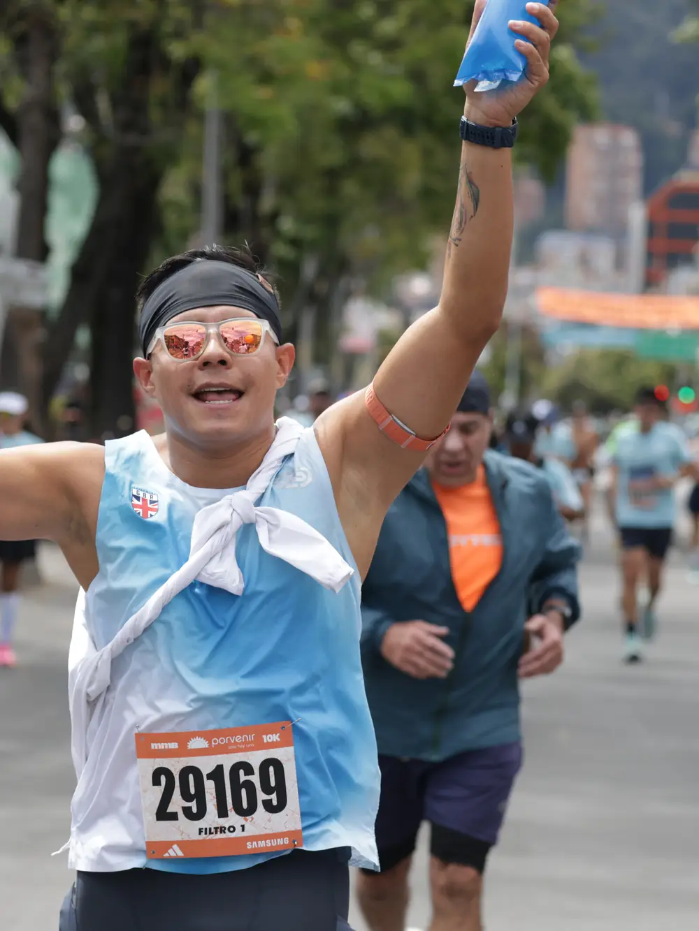 Un corredor de la Media Maratón de Bogotá levanta el brazo al pasar